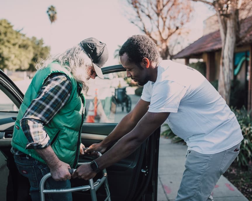Photo d'une personne aidant une personne âgée à sortir d'une voiture